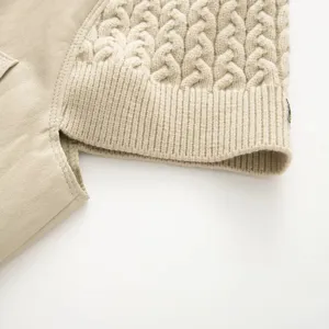 Dettaglio della manica della giacca in pelle e maglia con cuciture fini e classica trama a trecce