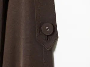 Brown trench coat sleeve cuff detail featuring matching fabric button and neat stitching.