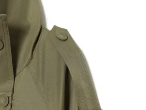 Close-up detail of women's olive green trench coat shoulder epaulet and collar.