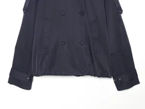 Women's navy blue short trench coat detail shot featuring double-breasted buttons, epaulets, and cuffed sleeves.