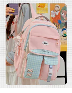 Vue de détail d'un joli sac à dos d'école rose et bleu en toile avec poches et bordure à carreaux.