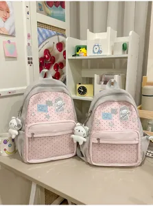 Joli sac à dos rose à pois avec motif de chien et pendentif en peluche pour les filles élégantes.