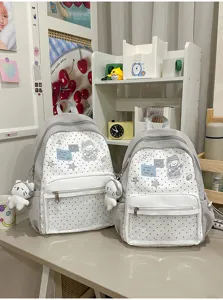 Sac à dos scolaire à pois mignon en toile, léger et décontracté avec peluche et joli patch.