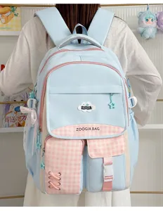 Vue détaillée du sac à dos d'étudiant bleu clair avec poches à carreaux roses et breloques.