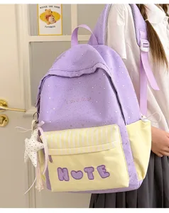 Vista dettagliata del simpatico zaino scolastico viola e giallo con motivi a stelle.