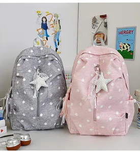 Grijze en roze canvas schoolrugzak met witte polkadots en een schattige sterhangerdetail.