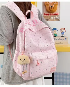 Pink star print school backpack detail shot, cute casual daily commuter bookbag with plush bear pendant.