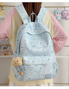 Close-up detail shot of the light blue star-printed backpack with cute cloud plush pendant.