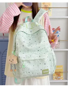 Detail shot of light green star print casual backpack with cute cloud pendant for daily commuting.