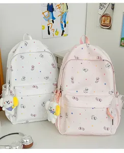 Detail view of cute cat print backpack with plush puppy charm, stylish and lovely design.