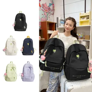 Detail view of casual canvas backpack featuring cute clover embroidery and pendant decoration.