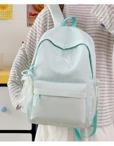 Vue détaillée d'un joli sac à dos à carreaux vert menthe avec élégante broderie nœud.