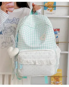 Sweet checkered student backpack with polka dot lace front pocket and cute heart pendant detail.