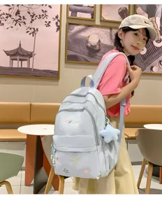 Lightweight blue student school backpack with cute star embroidery for daily travel use.
