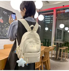 Casual beige backpack with cute star embroidery and plush pendant, perfect for daily travel use.