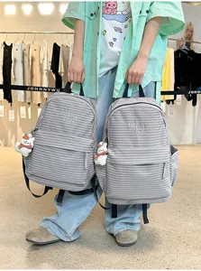 Grey checkered casual backpack with front pocket and side storage for daily school use.