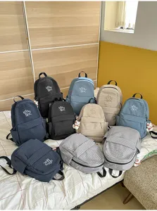 Detailed view of casual Korean style plaid and striped backpacks with cute pendants and front pockets.