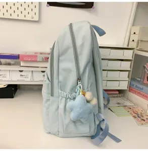 Light blue casual school backpack side detail with cute plush star pendant, daily travel bookbag.