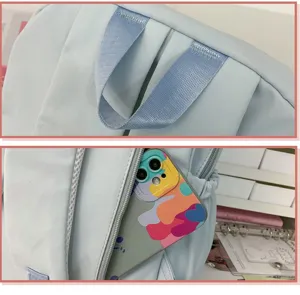 Detail view of the light blue casual backpack showing durable top handle and side pocket.