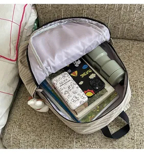 Detailed view of casual plaid backpack interior capacity, showcasing organized daily items.
