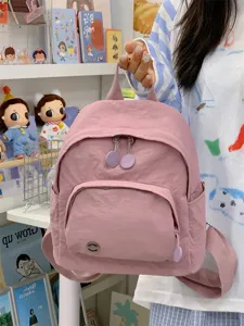 Pink mini backpack detail view, cute everyday casual daypack with front pocket and shoulder straps.