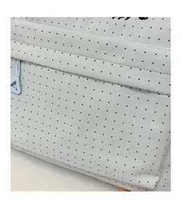 Close-up of light blue polka dot backpack front pocket detail with zipper design.