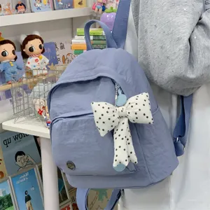 Minimalist mini backpack for women, cute casual style small school bag with polka dot bow.