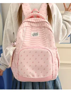 Dettaglio dello zaino rosa a righe carino con stampa a farfalla e ciondolo a stella.