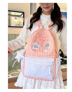 Detailed view of cute Korean style sweet gingham backpack with heart pocket and star patch.