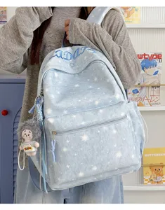 Light blue star print backpack detail with front zipper pocket and a cute side doll pendant.