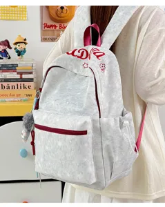 Close-up of casual grey printed school backpack featuring side pocket and red zipper details.