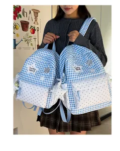 Detail shot of a cute blue and white checkered school backpack with sweet heart pockets and star patches.