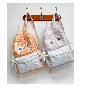 Detailed view of cute Korean style plaid school backpack with heart pocket and star pendant.