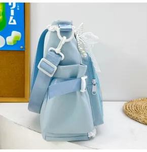 Detailed view of light blue ita bag featuring cute lace, elegant pearls, and adjustable straps.
