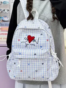 Detailed view of blue and white plaid backpack with cute heart embroidery and front pocket.