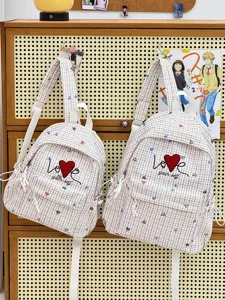 Detail view of Japanese style plaid backpacks featuring cute heart embroidery and lovely design.