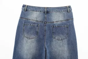 Detail view of women's blue washed denim jeans back pockets and high waist design.