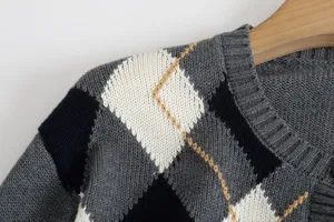 Nahaufnahme Detail der Damen grauen Argyle Strickjacke Schulter Textur und Muster Design.