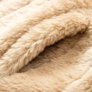 Detalle macro de suave tela de chaleco de polar caqui con textura esponjosa y cálida.