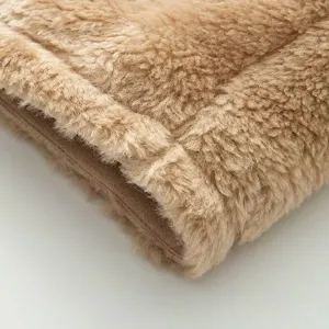 Primer plano detallado del suave tejido de forro polar teddy color cammello y textura.