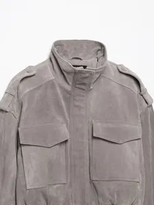 Graue Veloursleder Jacke Nahaufnahme mit Stehkragen Schulterklappen und Taschen.