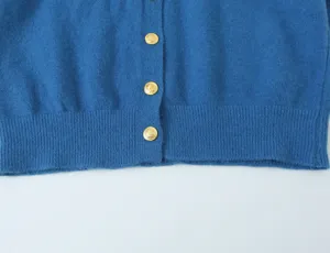 Blauwe gebreide vest voorzien van elegante goudkleurige knopen en geribbelde zoom.