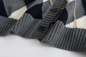 Strickjacke Detailaufnahme mit klassischem Rautenmuster, Rippbündchen und schicken Knöpfen.