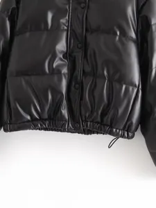Black faux leather puffer jacket detail showing snap button closure and elastic drawstring hem.