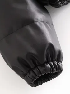 Close-up detail of black PU leather winter jacket sleeve with elastic gathered cuff.