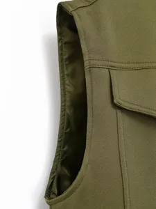 Olive green utility vest detail showing twill fabric, structured pocket and neat stitching.