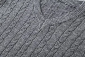 Detailed close-up of grey V-neck cable knit sweater, classic women autumn knitwear.
