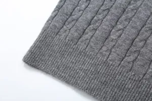 Grey cable knit sweater fabric detail showing soft texture and classic ribbed hem design.