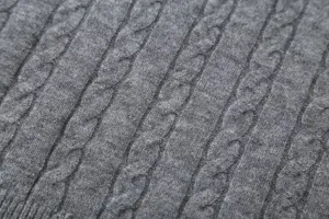 Grey cable knit sweater fabric detail closeup, soft wool blend texture for autumn winter apparel.