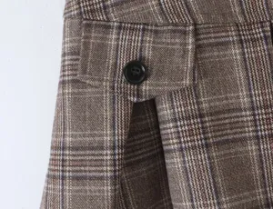 Brown plaid skirt detail, close up view of pocket and black button, stylish college style.